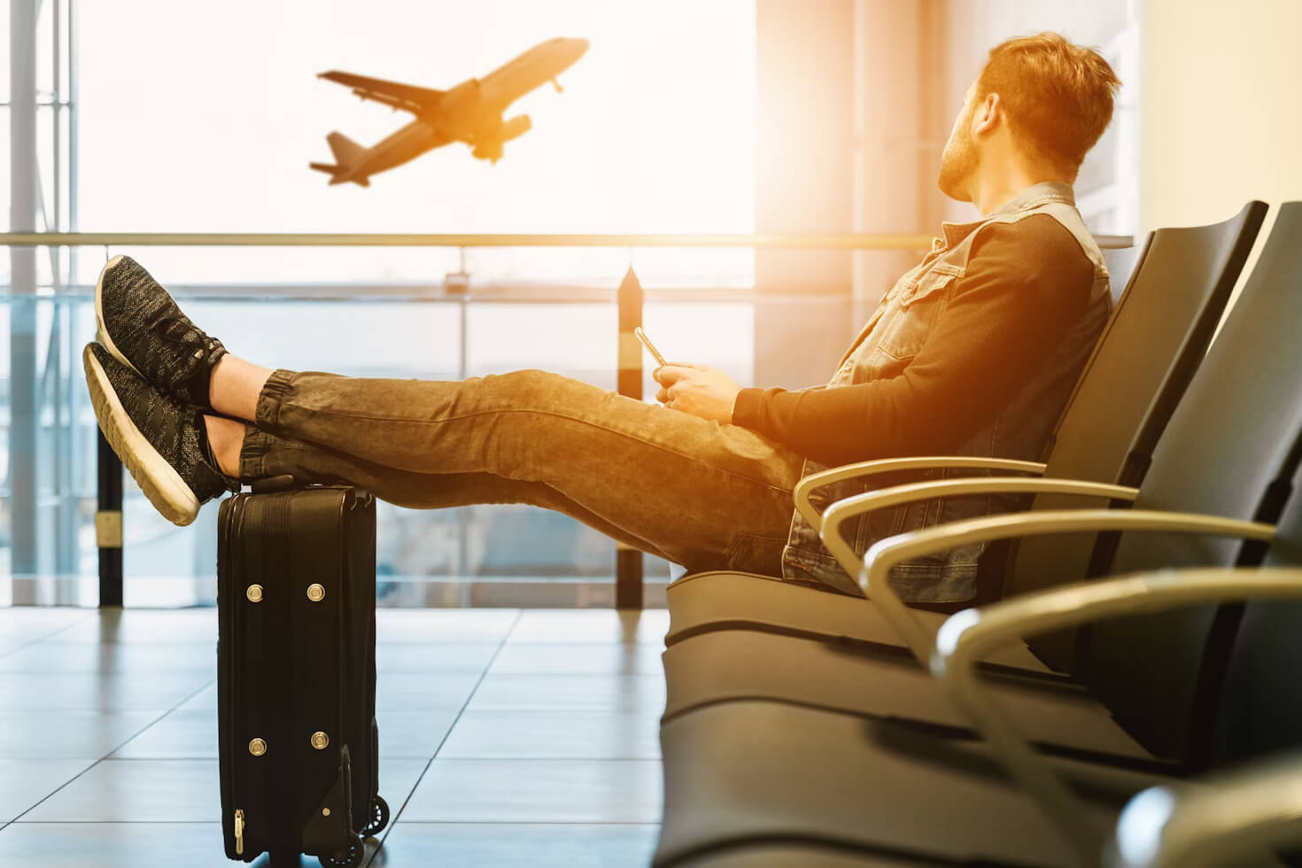 A man sitting in airport and thinking about the best solo travel destinations
